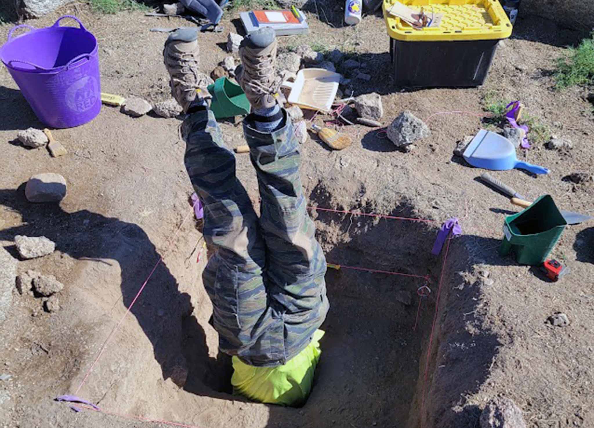 Person upside down in excavation unit